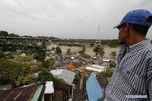 A man views the flooded houses at the neighborhood 'La Javilla' in Santo Domingo, capital of Dominica, Oct. 26, 2012.