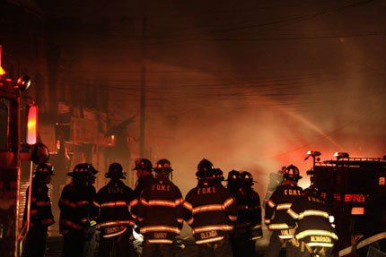 New York City firefighters battle a blaze on Rockaway Beach Boulevard yesterday. The fire raged near the Atlantic Ocean, with 80-100 homes destroyed. 