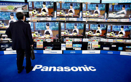 A man looks at Panasonic Corp's Viera televisions displayed at an electronics store in Tokyo in file photo. Panasonic Corp slashed its full-year earnings estimates to write down billions of yen of goodwill from past acquisitions in mobile phones and solar panels, a sign that its new president is scaling back businesses that do not add to the bottom line amid weak demand. [Photo/Shanghai Daily]