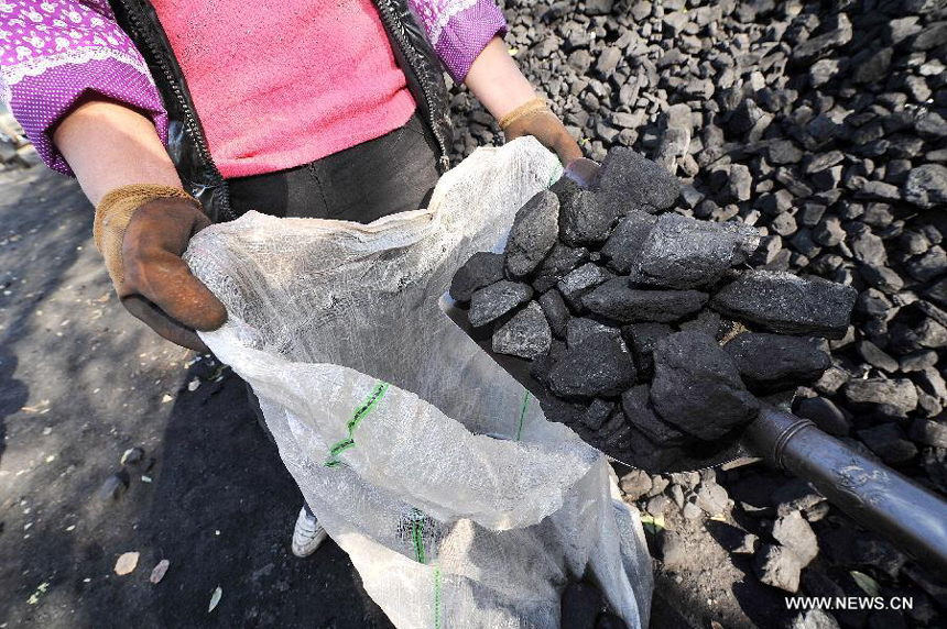 Two villagers collect coals at a coal yard in Xinmin Township of Jingyuan County, northwest China&apos;s Ningxia Hui Autonomous Region, on Oct. 31, 2012. As temperatures drop drastically in Ningxia, residents in its rural areas begin storing coals for heating in winter. Burning coals in winter is the most common way to keep out the cold in north China&apos;s rural areas lack of heating systems.