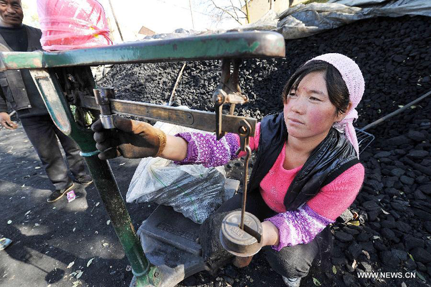 A villager weighs coals at a coal yard in Xinmin Township of Jingyuan County, northwest China&apos;s Ningxia Hui Autonomous Region, on Oct. 31, 2012. As temperatures drop drastically in Ningxia, residents in its rural areas begin storing coals for heating in winter. Burning coals in winter is the most common way to keep out the cold in north China&apos;s rural areas lack of heating systems. 