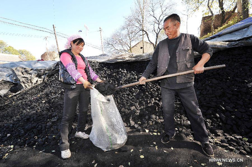 Two villagers collect coals at a coal yard in Xinmin Township of Jingyuan County, northwest China&apos;s Ningxia Hui Autonomous Region, on Oct. 31, 2012. As temperatures drop drastically in Ningxia, residents in its rural areas begin storing coals for heating in winter. Burning coals in winter is the most common way to keep out the cold in north China&apos;s rural areas lack of heating systems.