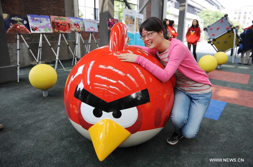 A visitor poses for a photo at an Angry Birds outdoor theme park in Shanghai, east China, Oct. 31, 2012. The theme park, which is located in Tongji University, covers an area of about 200 square meters. 