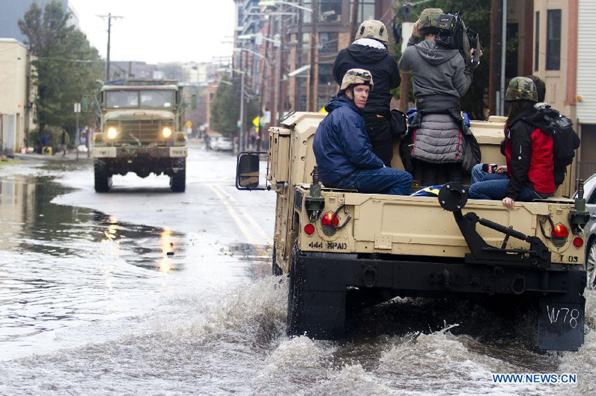 Journalists work on a National Guard truck in Hoboken of New Jersey, the United States, on Oct. 31, 2012. Hurricane Sandy lashed the U.S. east coast and made a landfall in New Jersey Monday evening, knocking out power for millions and killing at least 64 people. 