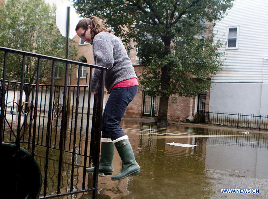 A resident tries to avoid deep flood water in Hoboken of New Jersey, the United States, on Oct. 31, 2012. Hurricane Sandy lashed the U.S. east coast and made a landfall in New Jersey Monday evening, knocking out power for millions and killing at least 64 people. 