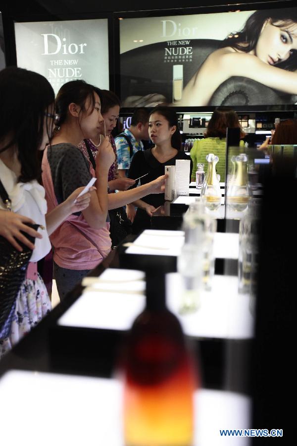  Tourists select cosmetics at a duty free shop in Sanya, south China&apos;s island province of Hainan, on Oct. 31, 2012.