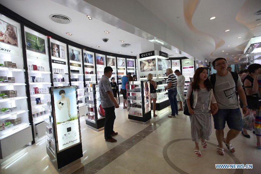 Tourists select cosmetics at a duty free shop in Sanya, south China&apos;s island province of Hainan, on Oct. 31, 2012.