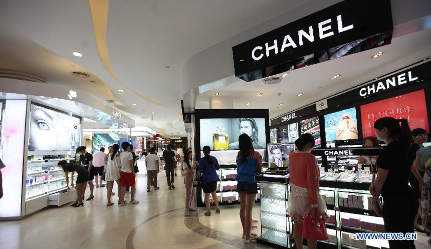 Tourists select cosmetics at a duty free shop in Sanya, south China&apos;s island province of Hainan, on Oct. 31, 2012. 