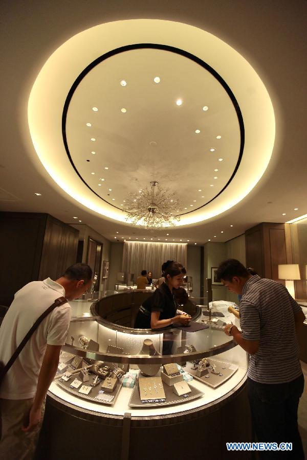 Tourists select jewelry at a duty free shop in Sanya, south China&apos;s island province of Hainan, on Oct. 31, 2012. 