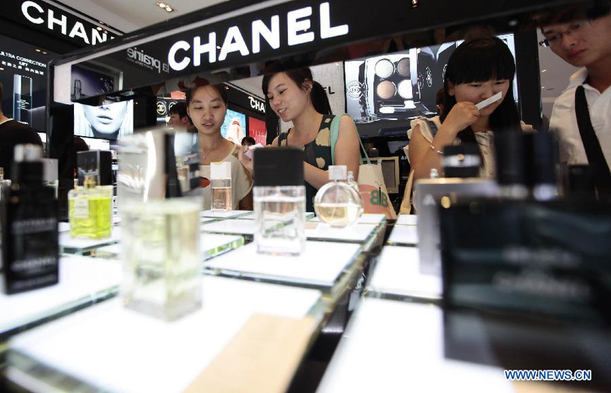 Tourists select cosmetics at a duty free shop in Sanya, south China&apos;s island province of Hainan, on Oct. 31, 2012. 