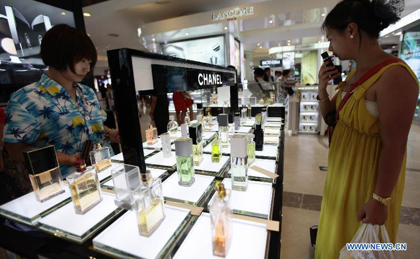 A tourist selects cosmetics at a duty free shop in Sanya, south China&apos;s island province of Hainan, on Oct. 31, 2012.