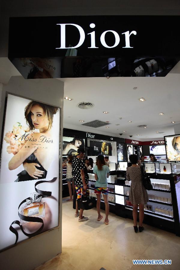 Tourists select cosmetics at a duty free shop in Sanya, south China&apos;s island province of Hainan, on Oct. 31, 2012. 