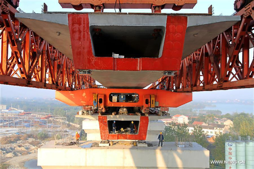 Workers install the last box girder at the construction site of the Huanggang Yangtze River Bridge in Huanggang, central China&apos;s Hubei Province, Nov. 2, 2012. The closure of the 4,008-meter-long bridge, which is the sixth combined bridge across the Yangtze River, finished on Friday. It is expected to be put into operation at the end of 2013.