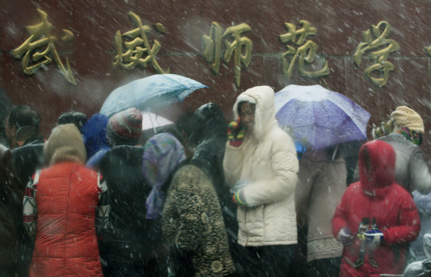 People wait for their children in front of a school in Wuwei, Gansu Province, on Nov.2, 2012. A cold wave hit northern parts of China these days. 