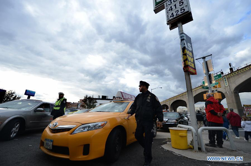 A policeman directs cars waiting to be refueled at a gas station in Queens, New York, the United States, Nov. 2, 2012. Four days after superstorm Sandy smashed into the U.S. Northeast, security measures were tightened up in New York as anger mounted over gasoline shortages, power outages and waits for relief supplies. 