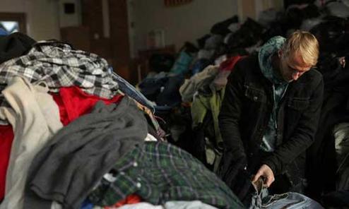 A man sifts through donated clothing at a distribution center November 4, 2012 in the Rockaway neighborhood of the Queens borough of New York City.