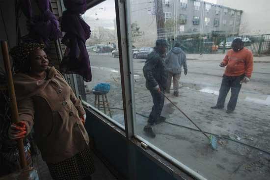 A woman pauses her cleaning to rest while working to remove the mud out of the Celestial Church of Christ in the Coney Island area of the Brooklyn borough of New York, November 4, 2012.