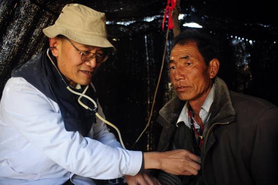 Wang Wanqing(L), a delegate of the 18th CPC National Congress and veteran surgeon, checks a herdsman's heart in Lanzhou, Gansu province, Nov 1, 2012. [Photo/Xinhua]