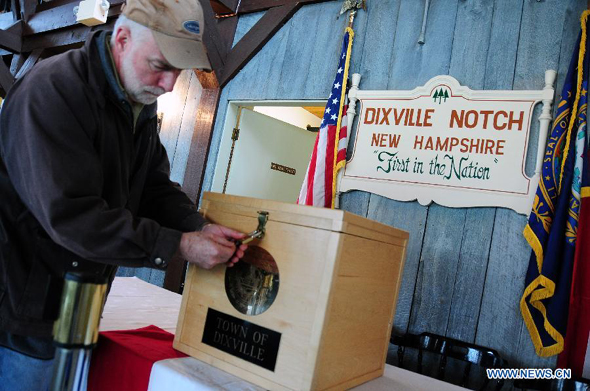A working staff locks the ballot box during the preparation for the voting at a polling station in Dixville Notch, New Hampshire, the United States, Nov. 5, 2012. Ten registered voters are expected to cast their ballots at the stroke of midnight on Tuesday Nov. 6, in Dixville Notch, signifying the official beginning of the voting in the 2012 U.S. presidential elections. [Xinhua]