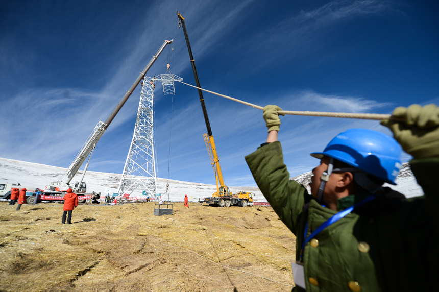 Workers build power towers on the Bayankala Mountain Pass on Nov. 6, 2012. It is the highest section of the 330-kilovolt project, which is expected to start operating in June of next year. The completion of the project will connect the isolated grid in the Yushu Tibetan Autonomous Prefecture with the main grid in Qinghai Province.