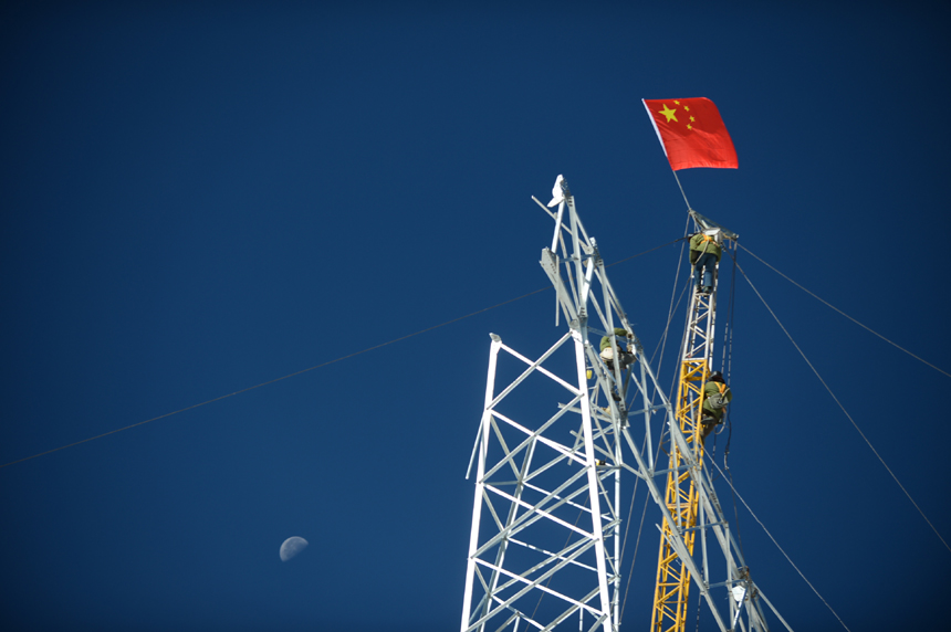 Workers build power towers on the Bayankala Mountain Pass on Nov. 6, 2012. It is the highest section of the 330-kilovolt project, which is expected to start operating in June of next year. The completion of the project will connect the isolated grid in the Yushu Tibetan Autonomous Prefecture with the main grid in Qinghai Province.