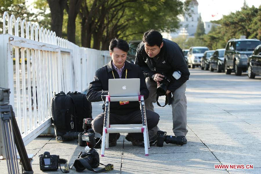 Xinhua photographers Xie Huanchi (L) and Wang Ye work during their coverage of the 18th National Congress of the Communist Party of China (CPC) at the Tian&apos;anmen Square in Beijing, capital of China, Nov. 8, 2012. The 18th CPC National Congress opened in Beijing on Thursday, which also marks the 12th Journalists&apos; Day of China. A total of 2,732 Chinese and foreign journalists are involved in the coverage of the 18th CPC National Congress. (Xinhua/Xing Guangli) 