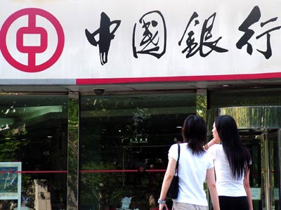 Two women walk into a branch of Bank of China in Shanghai. The Bank of China will expand in overseas markets by taking advantage of current low valuations to acquire financial assets cheaply. [File Photo]