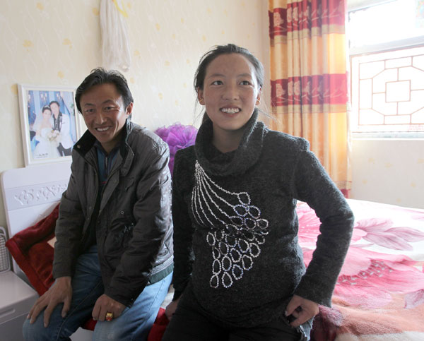 A couple, Kunsang Bartso (right) and Kunga Wangchen, live in a newly built house in Yushu. [Photo/China Daily]