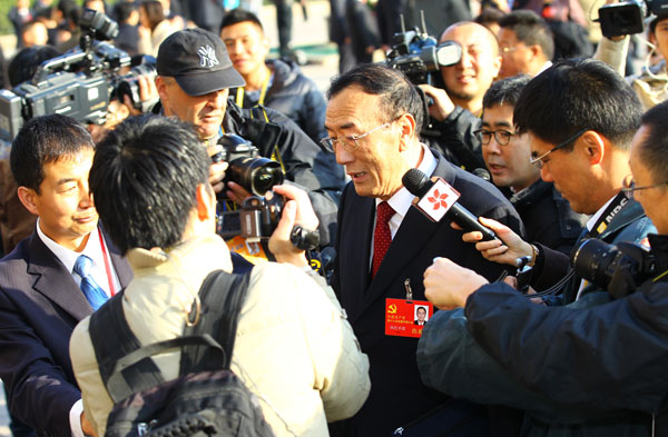 Qiangba Puncog (center), chairman of the Standing Committee of the Tibet People's Congress, speaks with reporters in front of the Great Hall of the People on Thursday in Beijing. [Photo/China Daily]