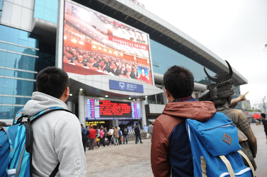 11月8日，旅客们在贵阳火车站站前广场上通过大屏幕观看十八大开幕会直播。当日，中国共产党第十八次全国代表大会在北京隆重开幕。[新华社]
