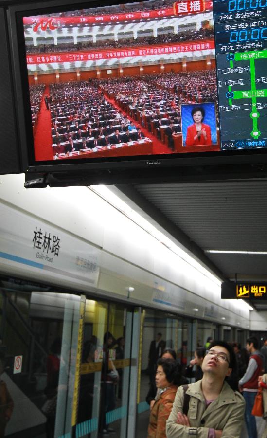 11月8日，上海市民在地铁站内观看十八大开幕会的电视直播。当日，中国共产党第十八次全国代表大会在北京隆重开幕。[新华社]