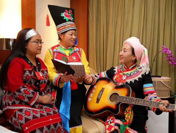The delegate from the Lahu ethnic group Li Naluo (Right), the delegate from the Blang ethnic group Yang Ziqin (Center) and the delegate from the Va ethnic group Chen Fengxian perform Li's self-composed song 'Thanks to the CPC' in Beijing on Nov 10, 2012. [Xinhua]
