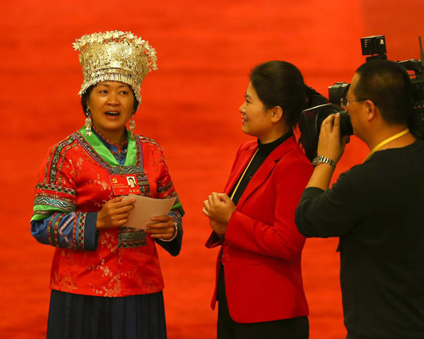 11月9日，在参加完湖南代表团讨论后，十八大代表、苗乡老师兰朝红接受采访时唱起了苗歌。[新华社]