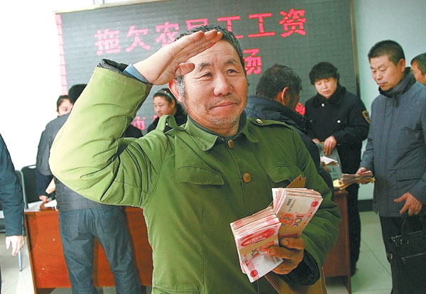 A migrant worker salutes government officials after he and 76 others received a total of 2.5 million yuan ($400,000) in overdue wages, thanks to the help of labor supervisors in Chaoyang, Liaoning province, this year. [Photo/Xinhua]