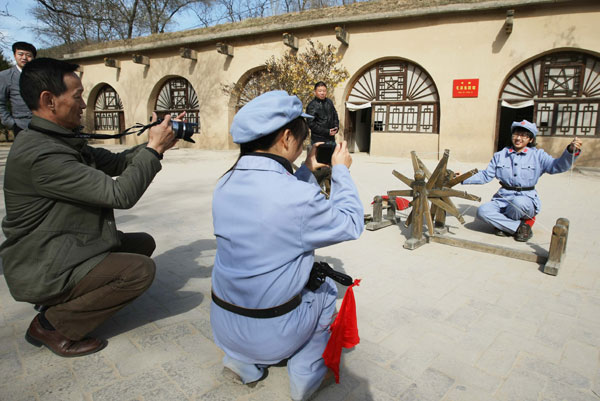 Tourists dressed as Red Army soldiers pose for pictures at the Zaoyuan historical site in Yan'an, Shaanxi province, on Nov 1.[Photo/Xinhua]