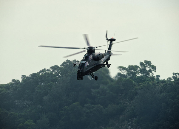 我国自主研制生产的武直-10武装直升机11日飞临珠海三灶机场上空，为即将开幕的珠海航展进行表演预演。[新华社]