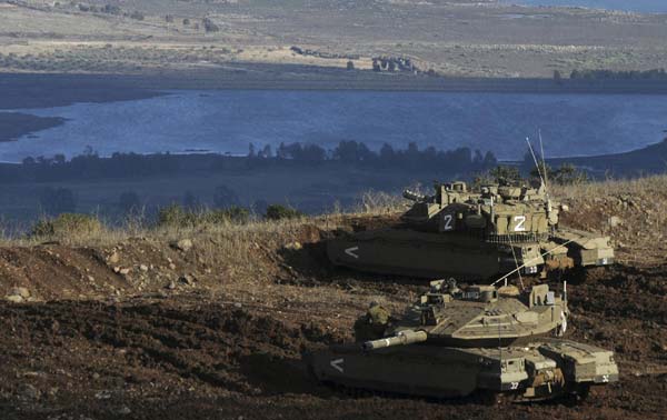 Israeli tanks stand in position overlooking a Syrian village from the Israeli-occupied Golan Heights Nov 12, 2012. [China Daily/Agencies]