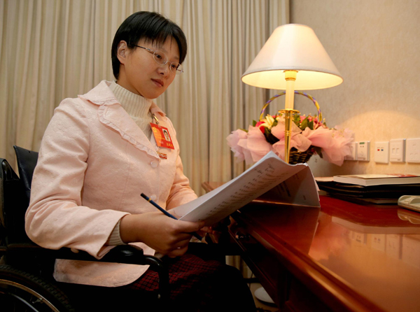 Hou Jingjing, CPC delegate, reads reports in her hotel room in Beijing, Nov 11.[Photo/Xinhua]