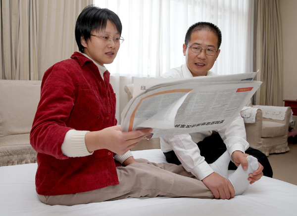 Hou Jingjing's husband Xiang Huali massages her feet in her hotel room in Beijing, Nov 11.[Photo/Xinhua]