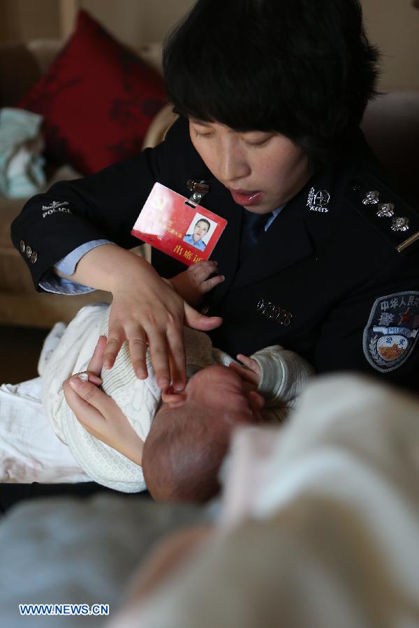 Jiang Min, a delegate to the 18th National Congress of the Communist Party of China (CPC), puts ointment on the face of her son, who had eczema, in Beijing, capital of China, Nov. 13, 2012. 