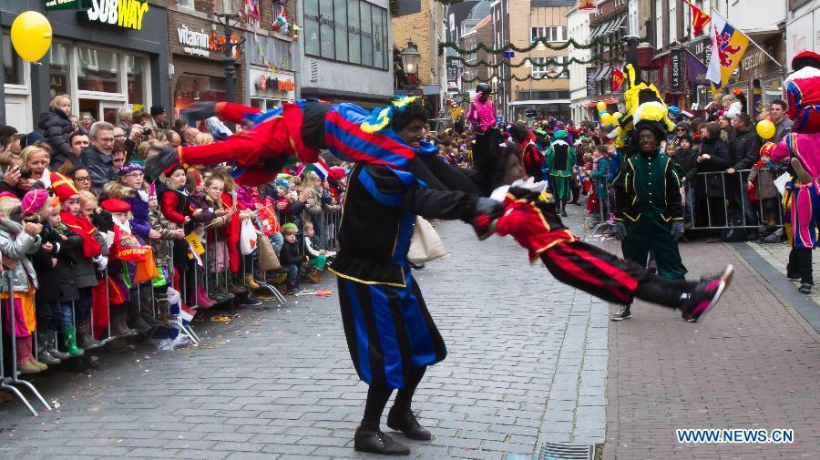 Zwarte Piet, companion of Sinterklass, the character of Santa Claus, appear on the street during a celebration to welcome Sinterklass in Roermond, the Netherlands, Nov. 17, 2012.