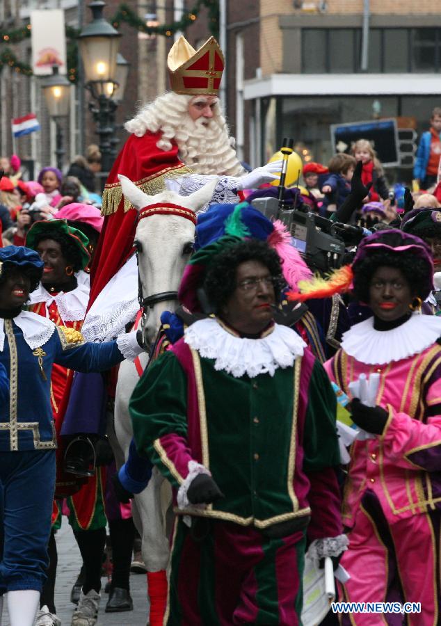 Sinterklass, the character of Santa Claus, and his companion Zwarte Piet appear on the street during a celebration to welcome him in Roermond, the Netherlands, Nov. 17, 2012.