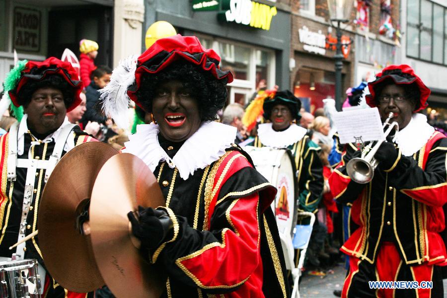 Zwarte Piet, companion of Sinterklass, the character of Santa Claus, appear on the street during a celebration to welcome Sinterklass in Roermond, the Netherlands, Nov. 17, 2012.