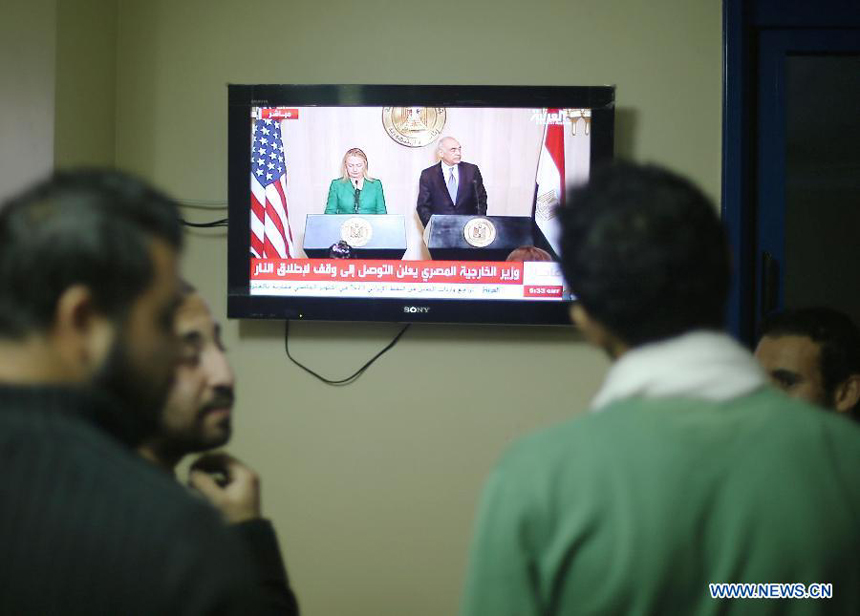 Palestinians watch TV for a press conference of U.S. Secretary of State Hilary Clinton and Egyptian Foreign Minister Mohamed Kamel Amr, Nov. 21, 2012. Mohamed Kamel Amr announced here that the ceasefire between Israel and Gaza militant groups will take effect at 9:00 p.m. local time ( 1900 GMT) on Wednesday.