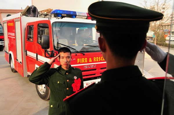 A retired soldier salutes to a sentry in Lanzhou, capital city of Northwest China's Gansu province on Nov 25, 2012. The date is the national retirement day for Chinese soldiers as most veterans leave the army for their hometown around this day. [Photo/Xinhua]