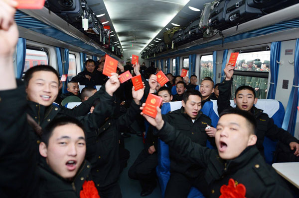 Newly retired soldiers hold up their retirement certificates on a train leaving for the eastern city of Jinan from Chongqing municipality in southwest China on Nov 25, 2012. [Photo/Xinhua]