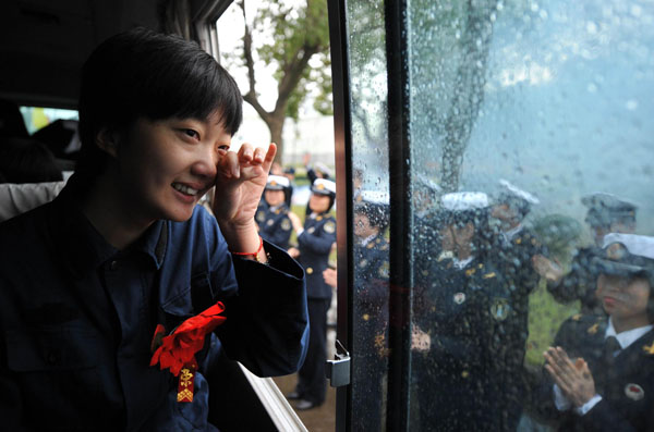 A retired female soldier is moved to tears as she leaves the army for home in Zhoushan, East China's Zhejiang province, on Nov 25, 2012. [Photo/Xinhua]