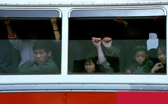 People wearing then-popular green attire ride a bus.