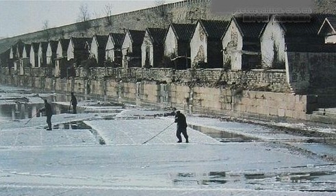 People collect ice from a river.