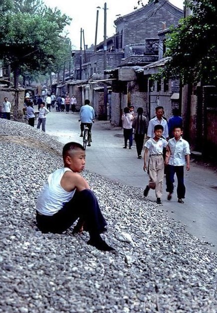 People walk on a neighborhood street which is due to be reconstructed.